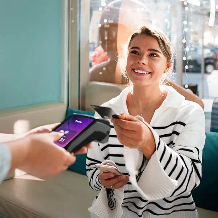 A customer paying with their card tapping on a Fresha Terminal at checkout